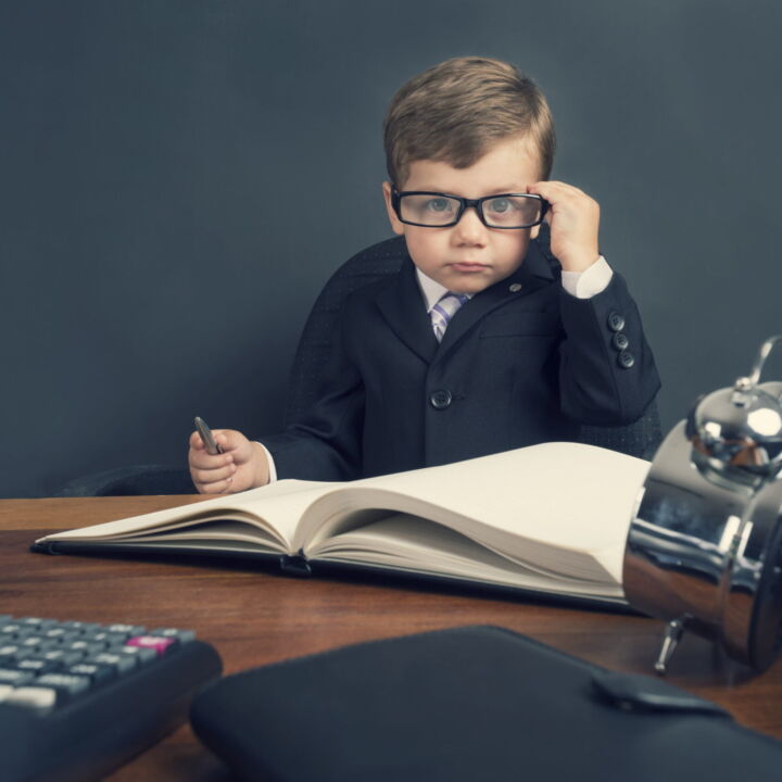 Junger Junge im Anzug arbeitet am Schreibtisch